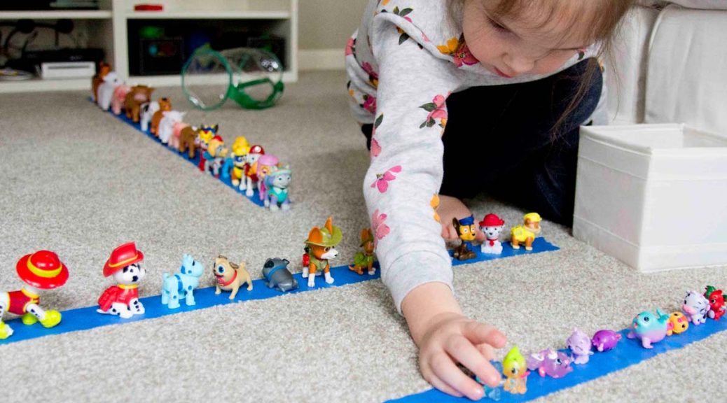 toddler lines up toys